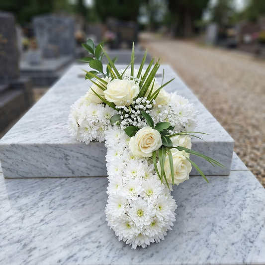 Aranjament funerar in forma de cruce, predominant alb, cu trandafiri ivoire si verdeata discreta