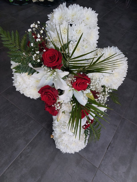 Aranjament funerar in forma de cruce, realizat din crizantema cu accente de trandafiri rosii si crini albi