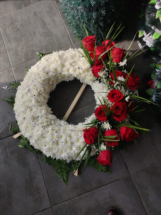Aranjament funerar rotund cu crizantema, completat de trandafiri rosii